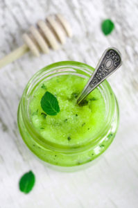 Mint and honey face and body scrub in a small glass jar