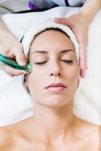 Portrait of beautiful young woman receiving cupping treatment in spa.