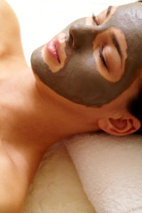Relaxed girl with clay or mud mask on face for pore cleaning