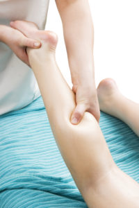 A detail image of a female leg being massaged.