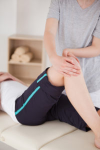 Portrait of a sportswoman having a knee massage